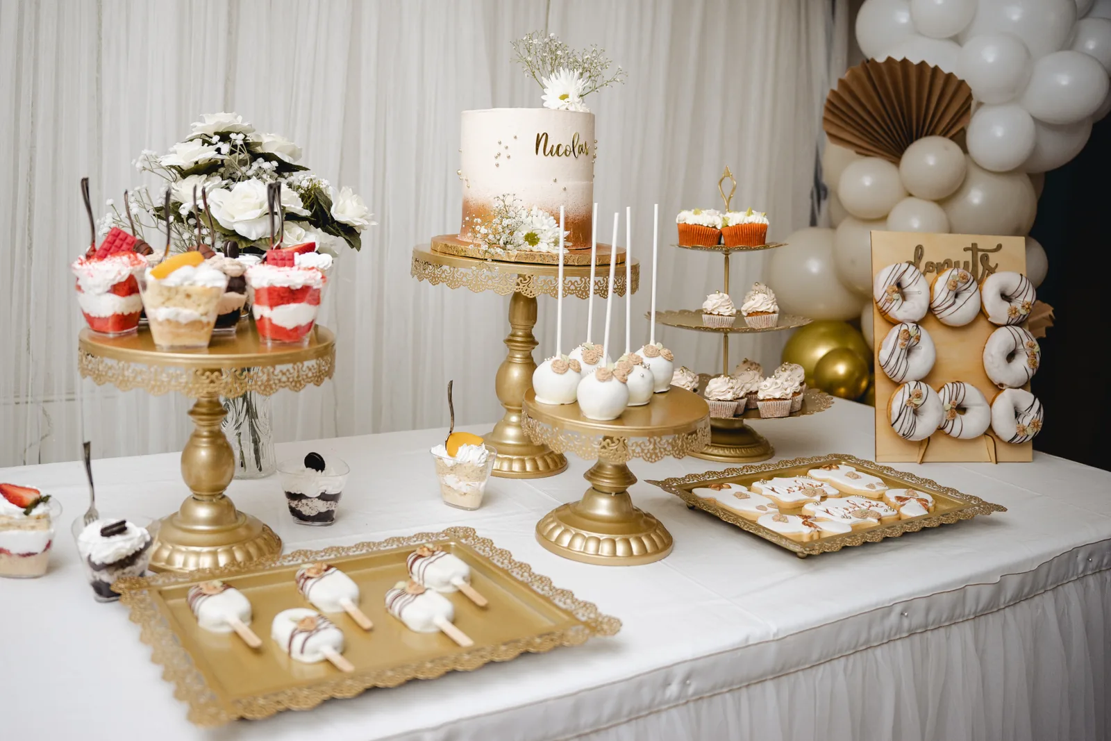 Mesa dulce completa con tarta central, cupcakes, donuts y galletas personalizadas